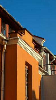 Stunning view of a modern building with an orange facade against a clear blue sky.
