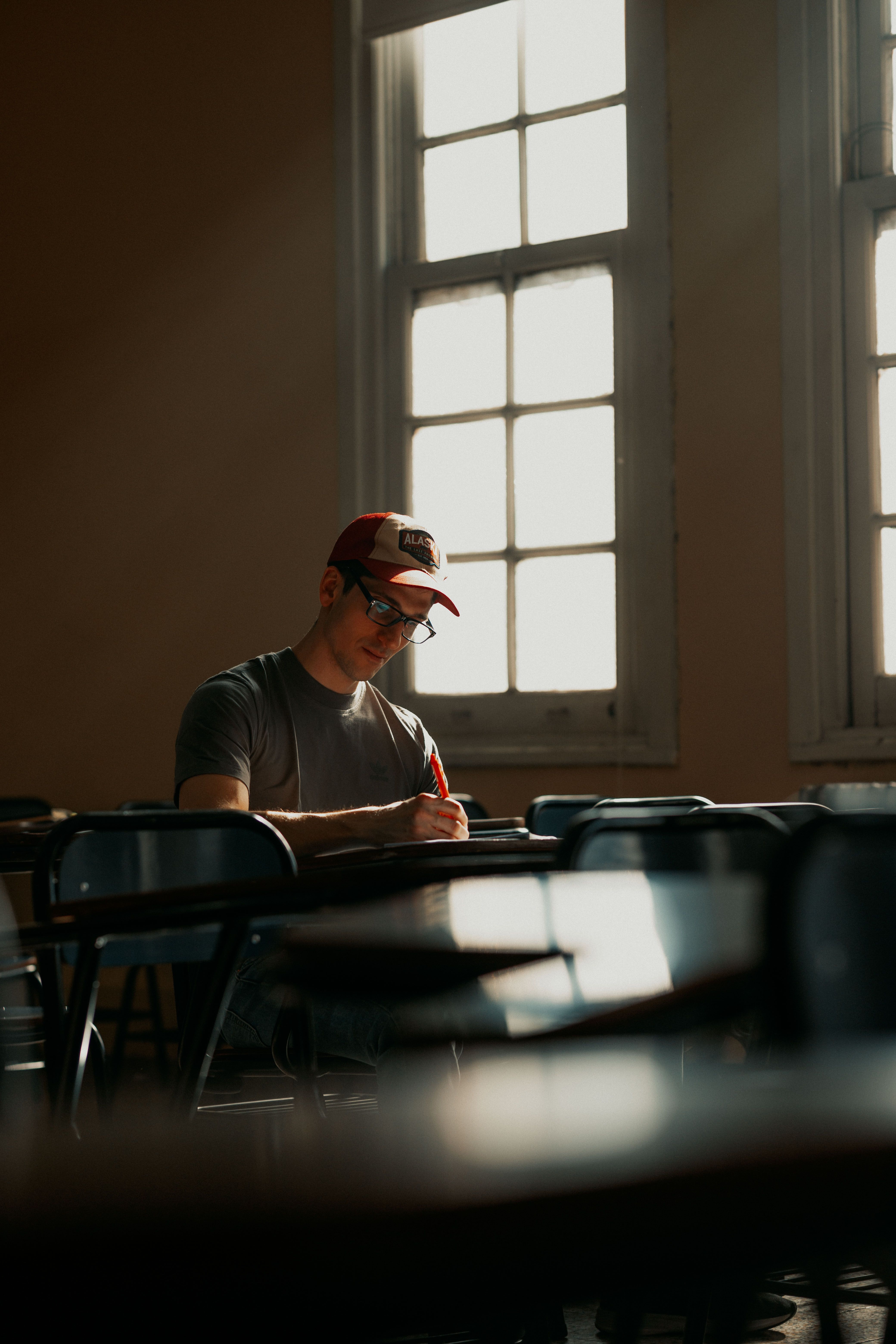 A student focused on studying in a sunlit classroom in Buenos Aires, Argentina.