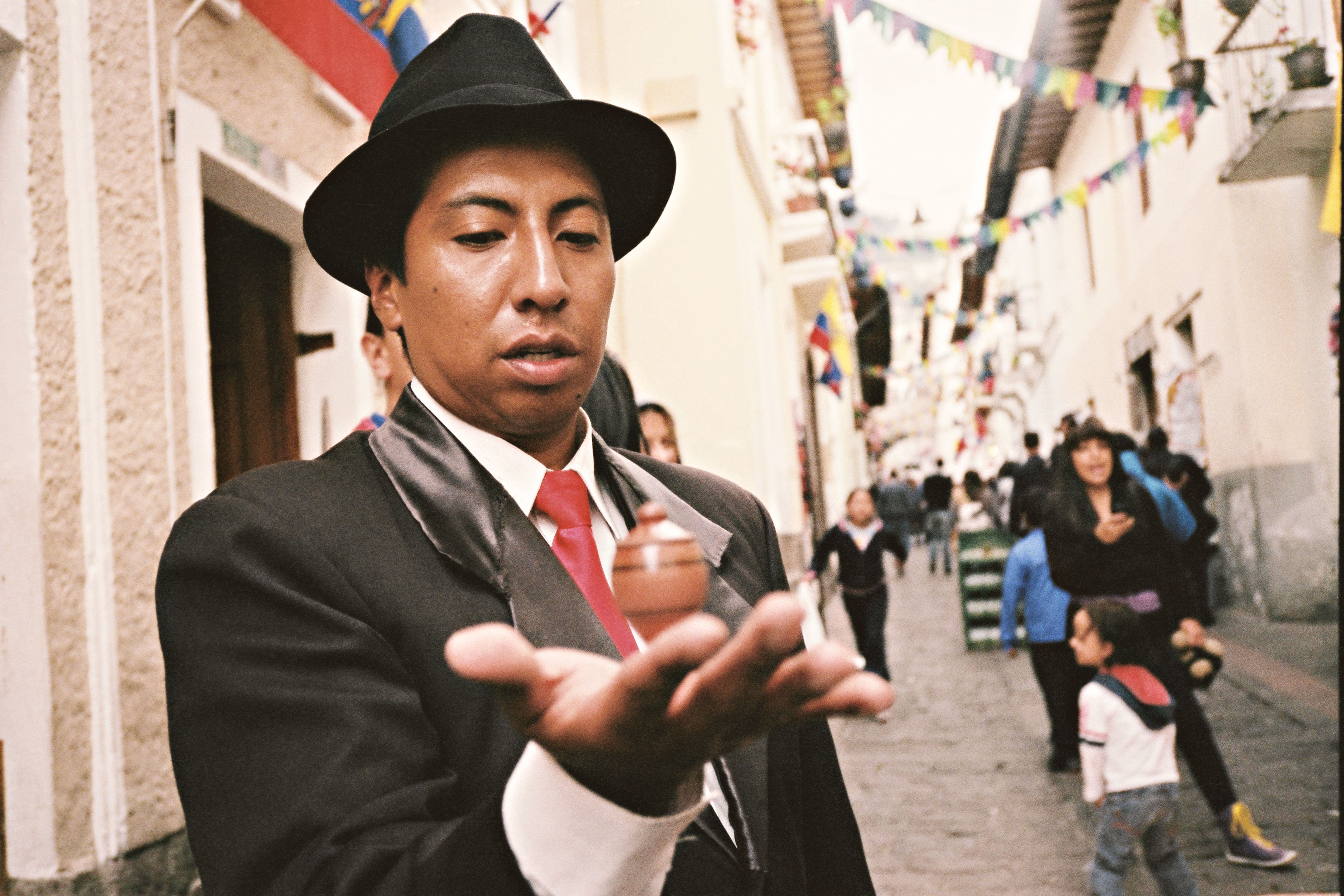 A man in traditional attire performs on the streets of Quito, Ecuador, captivating an audience.