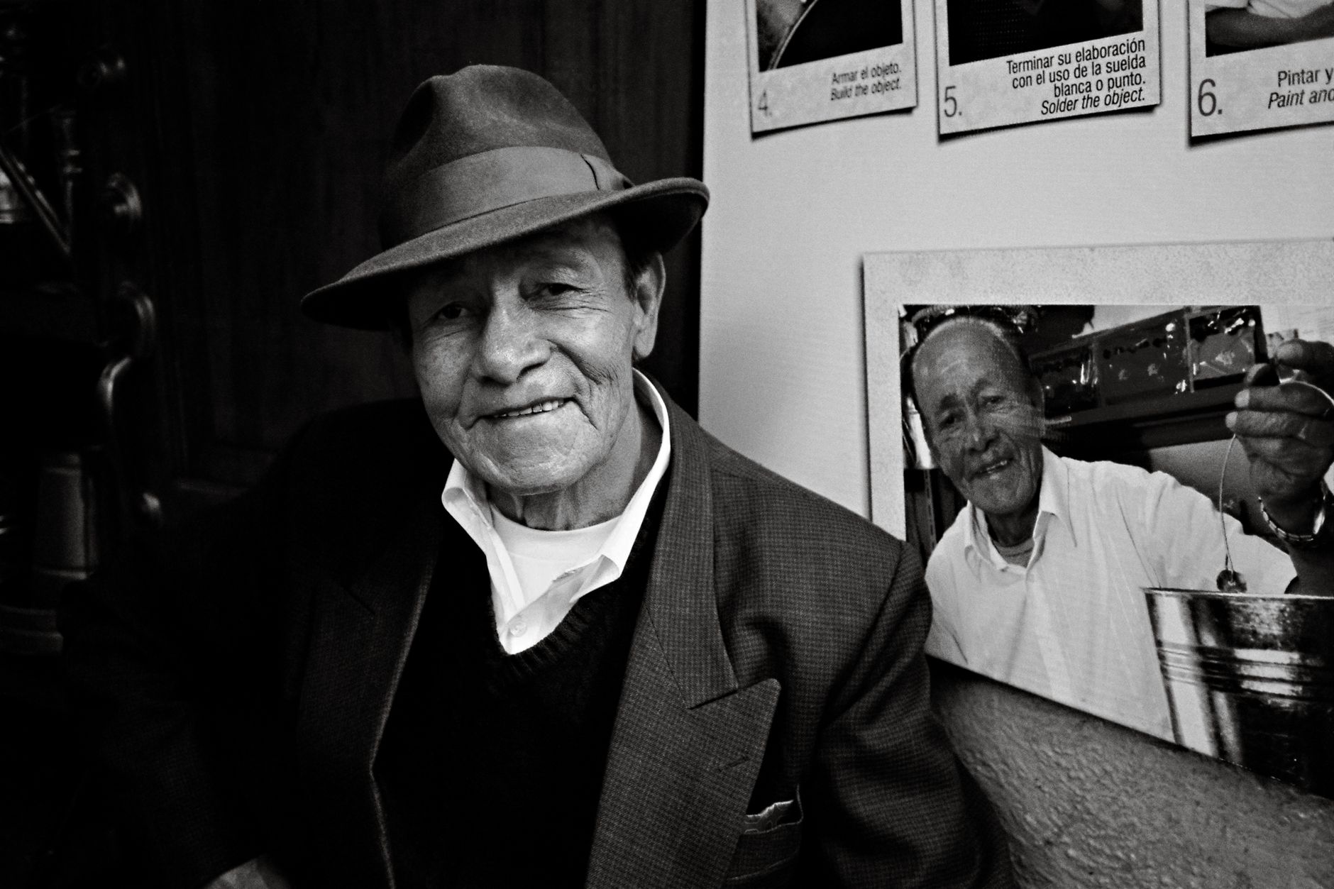 Black and white portrait of an elderly man wearing a hat indoors, capturing a nostalgic and classic mood.