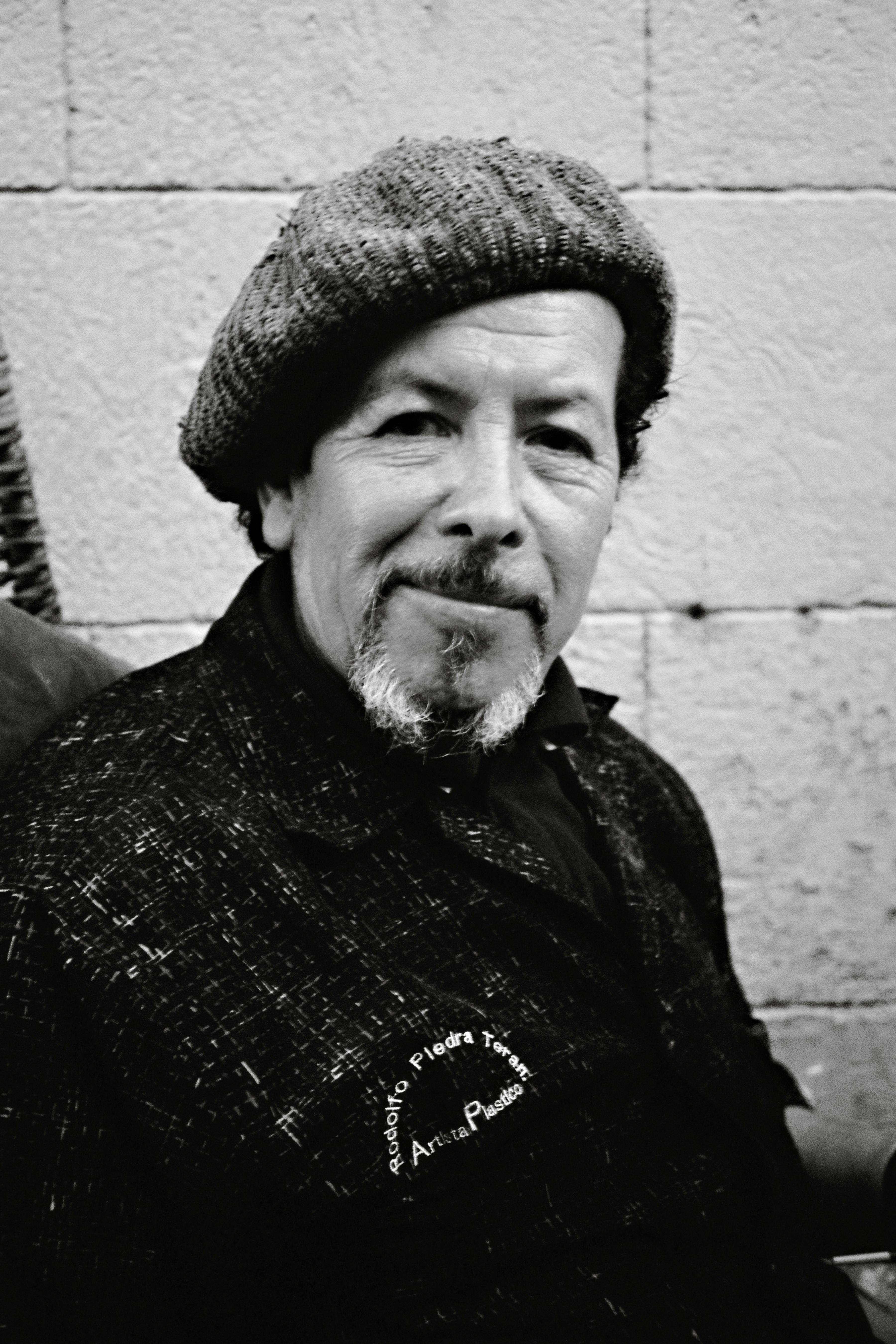 Black and white portrait of a senior man wearing a beret, captured in Quito, Ecuador.