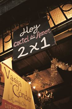 Chalkboard sign promoting cocktails with a 2 for 1 offer at a Quito venue.