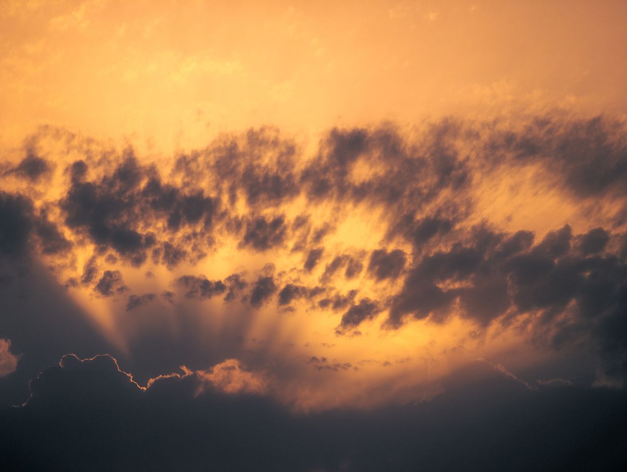 a captivating sunset with rays of light piercing through dark clouds c