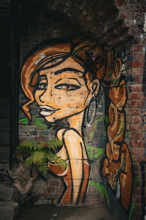 Free Colorful graffiti of a woman on a brick wall, showcasing urban art in Breslau. Stock Photo
