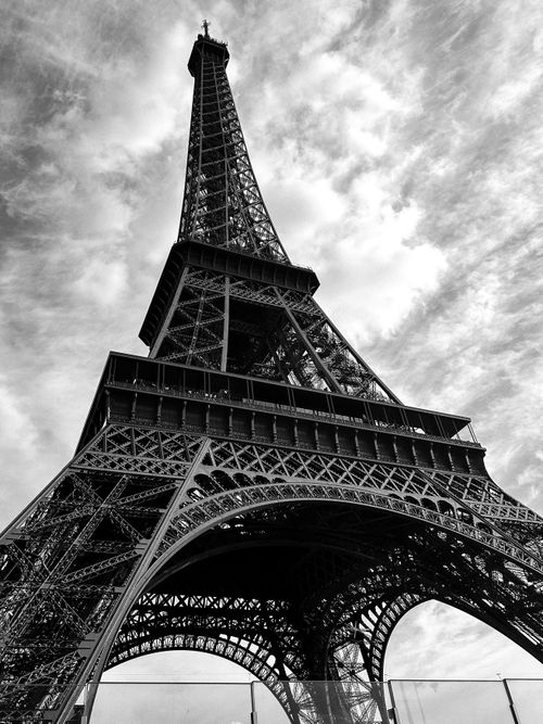 Free Striking black and white shot of the Eiffel Tower against a cloudy sky. Stock Photo