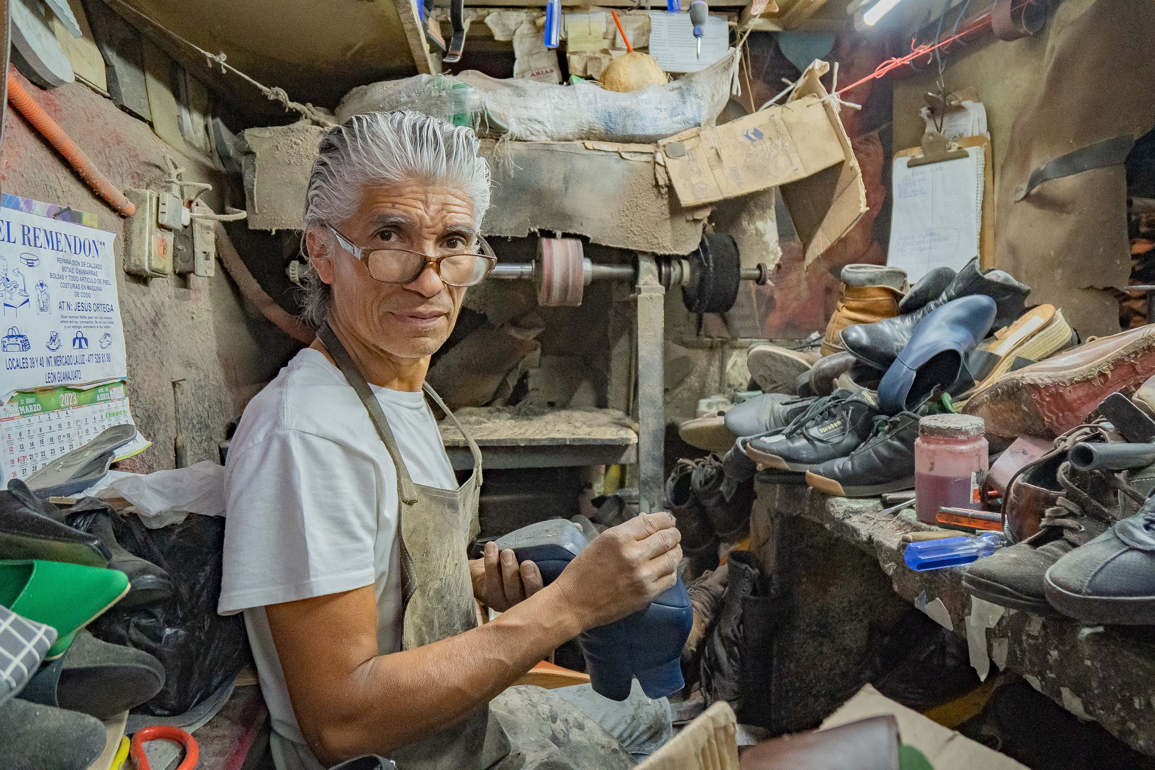 Inside a traditional shoe repair workshop with tools and leather goods