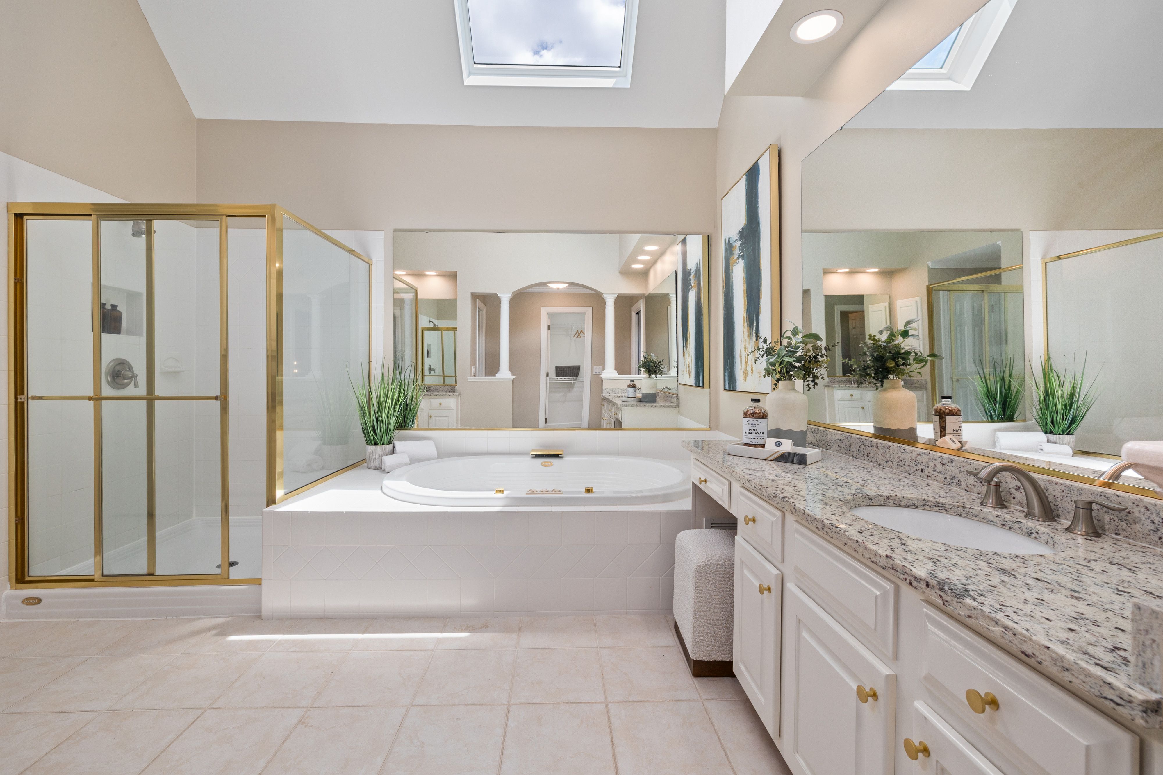 Spacious modern spa bathroom with tub and skylight