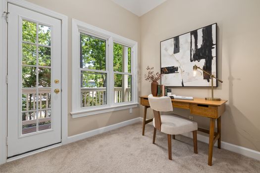 Bright home office interior with natural light, elegant desk, and abstract artwork.