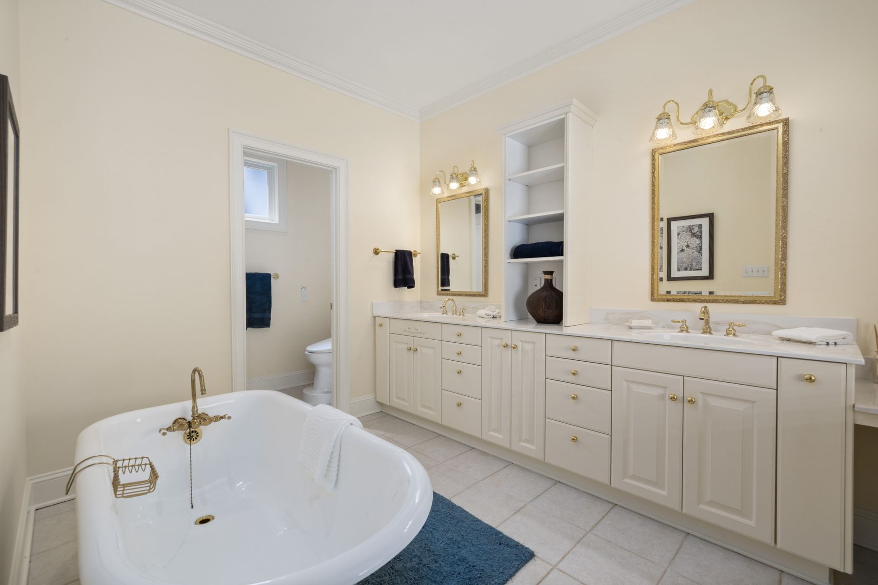 Balanced double vanity with framed cabinetry, mirrors and substantial storage