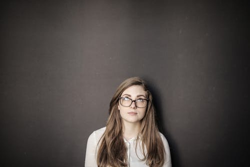 Woman in White Long Sleeve Shirt Wearing Eyeglasses