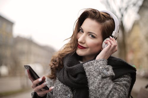 Free A Photo Of A Woman Listening To Music On White Headphones Stock Photo