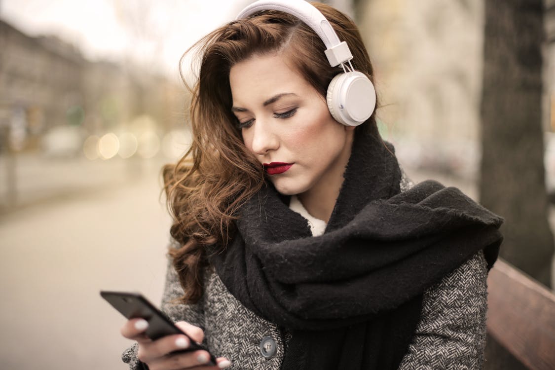 Woman in Black Scarf Holding Black Smartphone