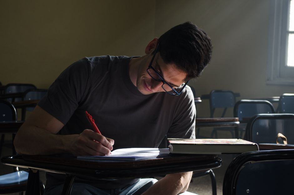 Young man studying in a Buenos Aires classroom, focused on writing notes. Young man studying in a Buenos Aires classroom, focused on writing notes.