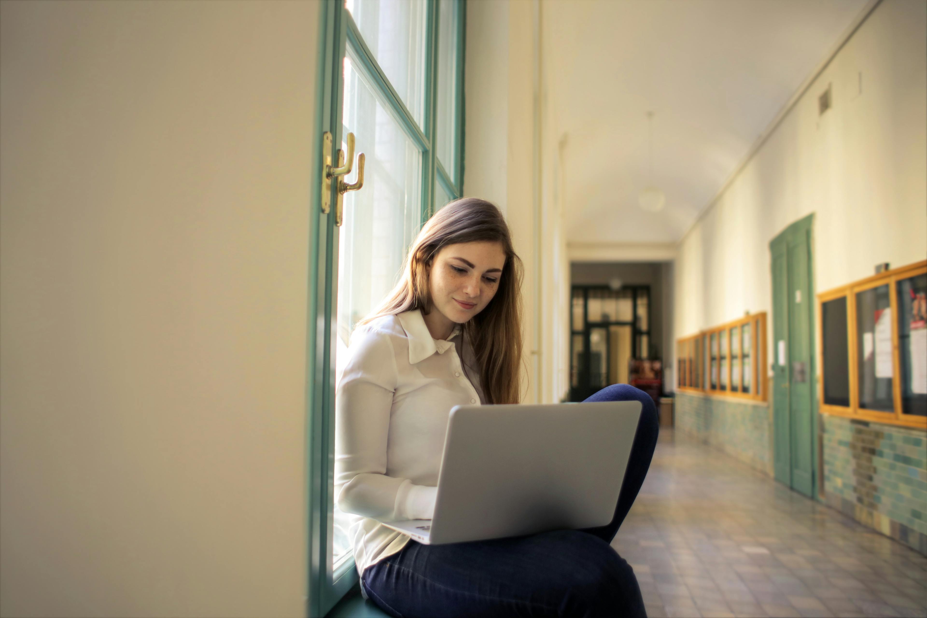 Woman in White Long Sleeve Shirt Using Macbook