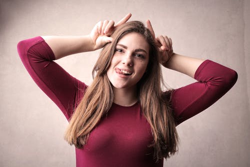 Donna In Camicia A Maniche Lunghe Rossa Che Fa Una Faccia Buffa