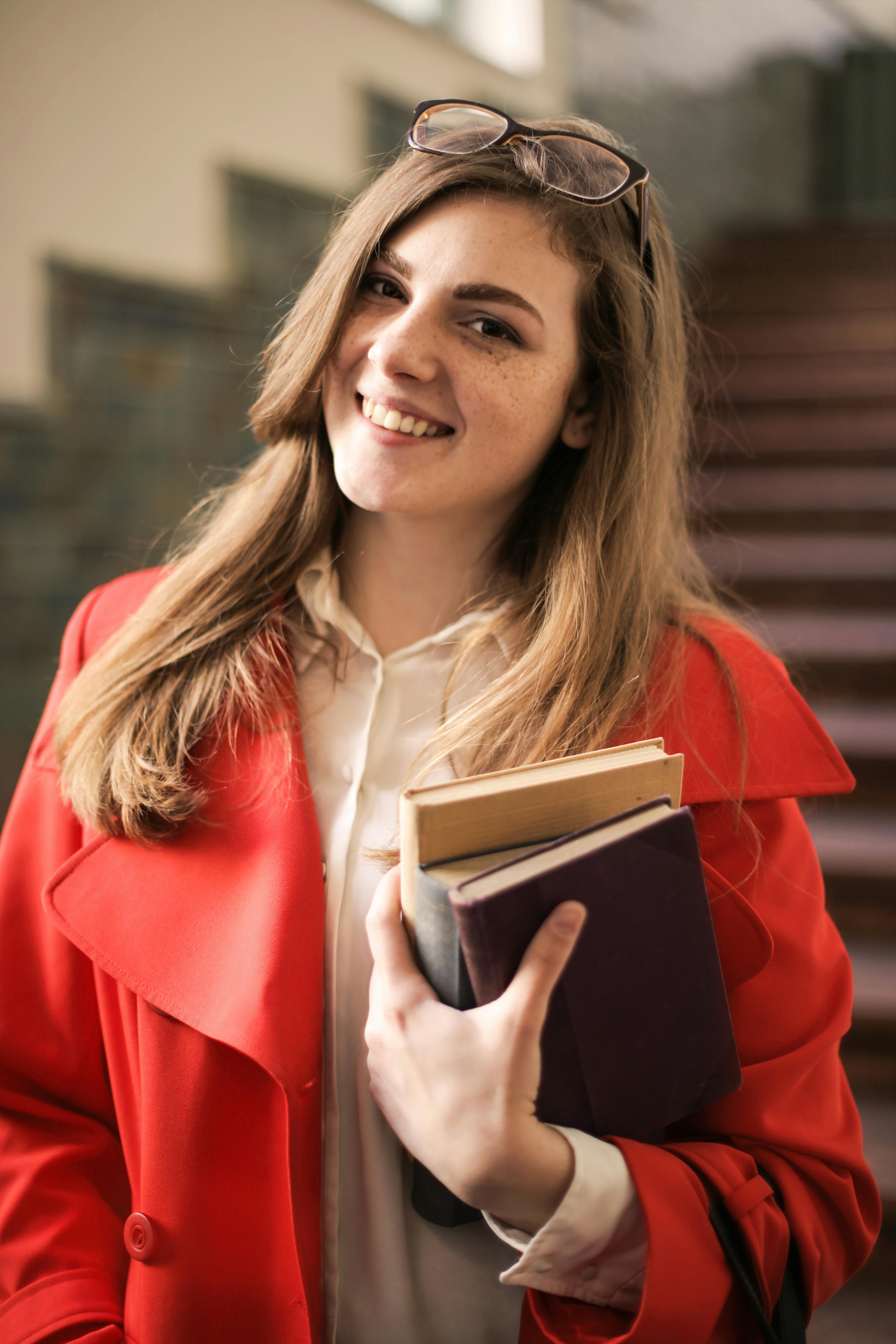 woman in red coat holding book