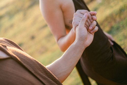 Free A romantic close-up of two adults holding hands in an outdoor setting, conveying love and connection. Stock Photo