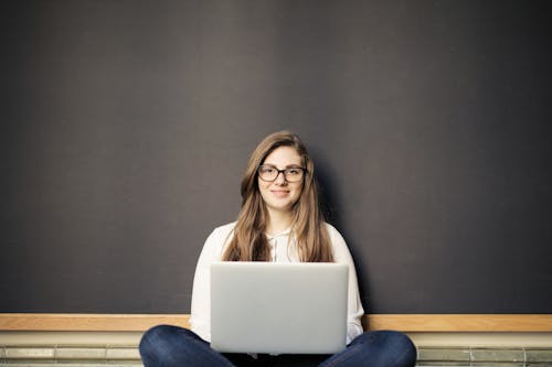 ノートパソコンを使用しながら笑顔の女性