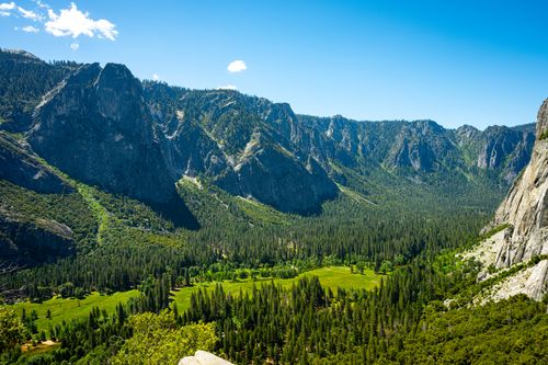 Free Stunning aerial view of Yosemite Valley with lush greenery and towering mountains under a clear blue sky. Stock Photo