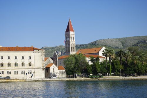 Free Scenic view of Trogir waterfront with the bell tower of St. Lawrence Cathedral against a mountainous backdrop. Stock Photo