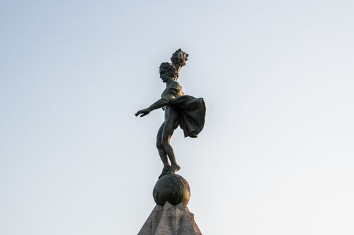 Free A striking statue of Atlas with dynamic pose, captured under a clear evening sky. Stock Photo