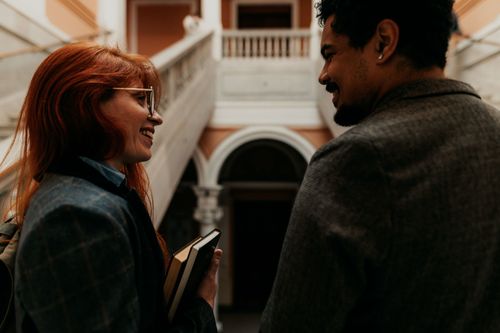 Free Two university students smiling at each other in a historic building in Buenos Aires. Stock Photo