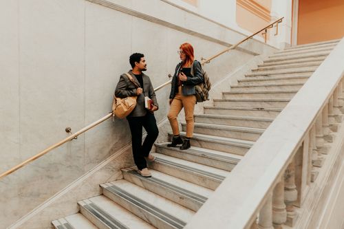 Free Two university students talking on a marble staircase indoors. Stock Photo
