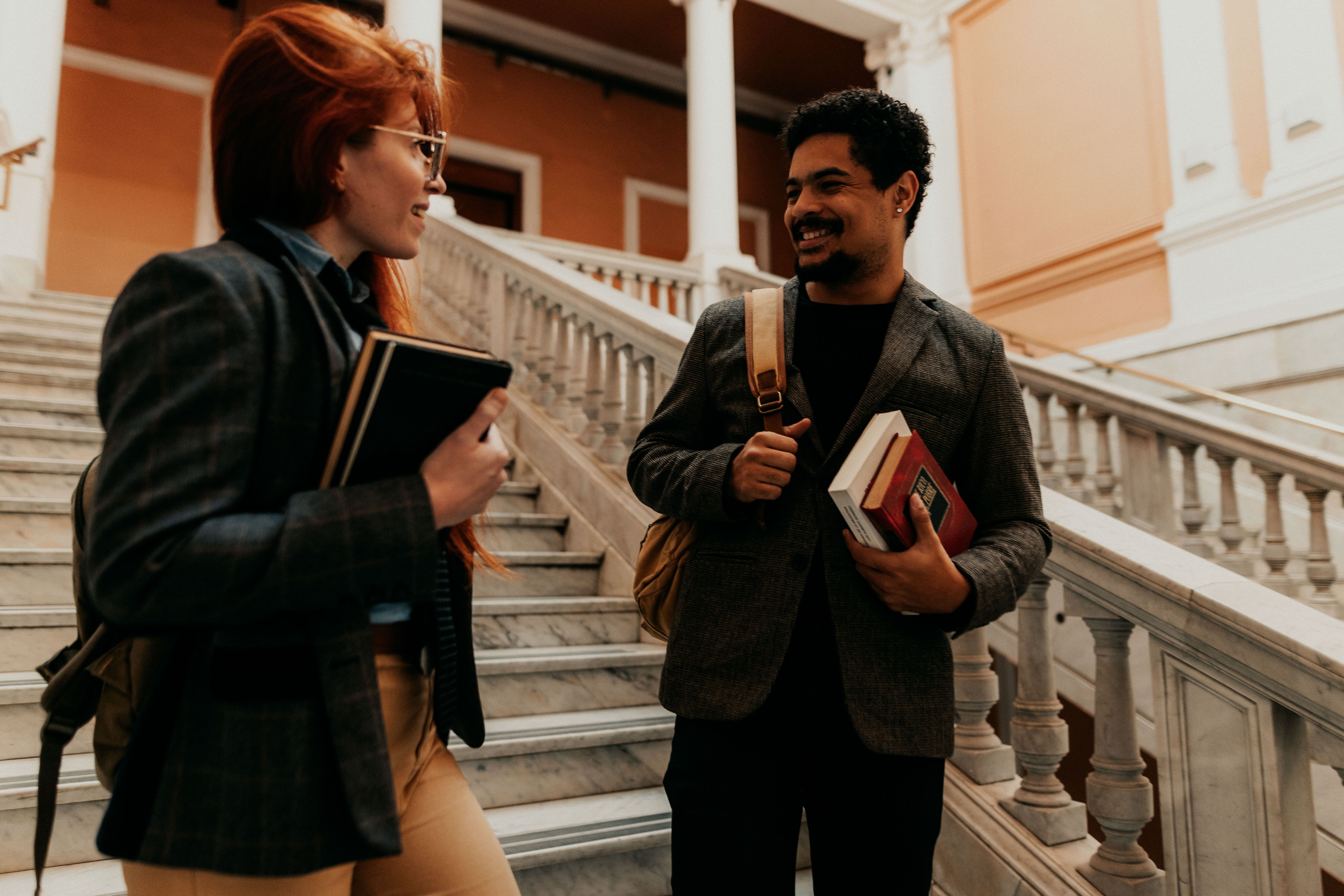 Two professionals sharing a conversation while holding books