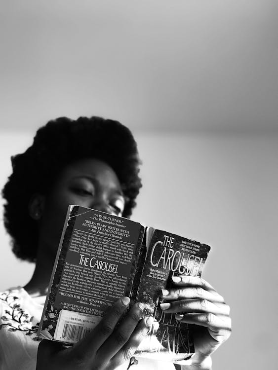 Grayscale Photo of Woman Holding Book