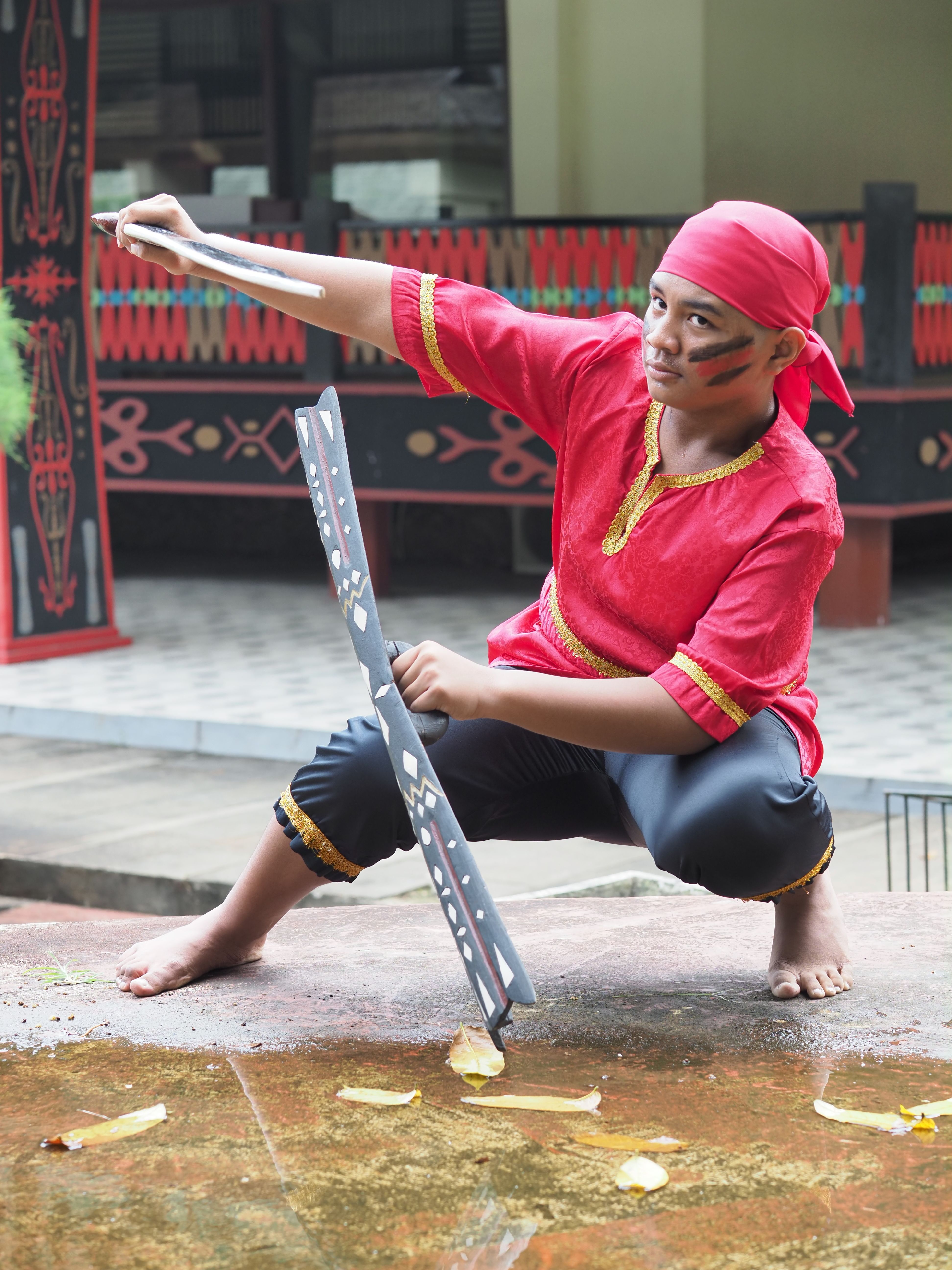 Young man in traditional attire performing a warrior dance in Jakarta, Indonesia.