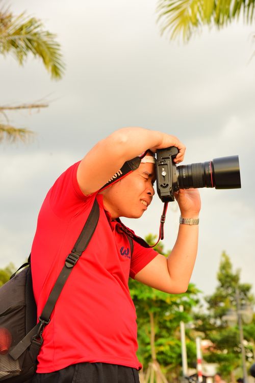 Free A photographer takes pictures outdoors, showcasing dedication and focus. Stock Photo