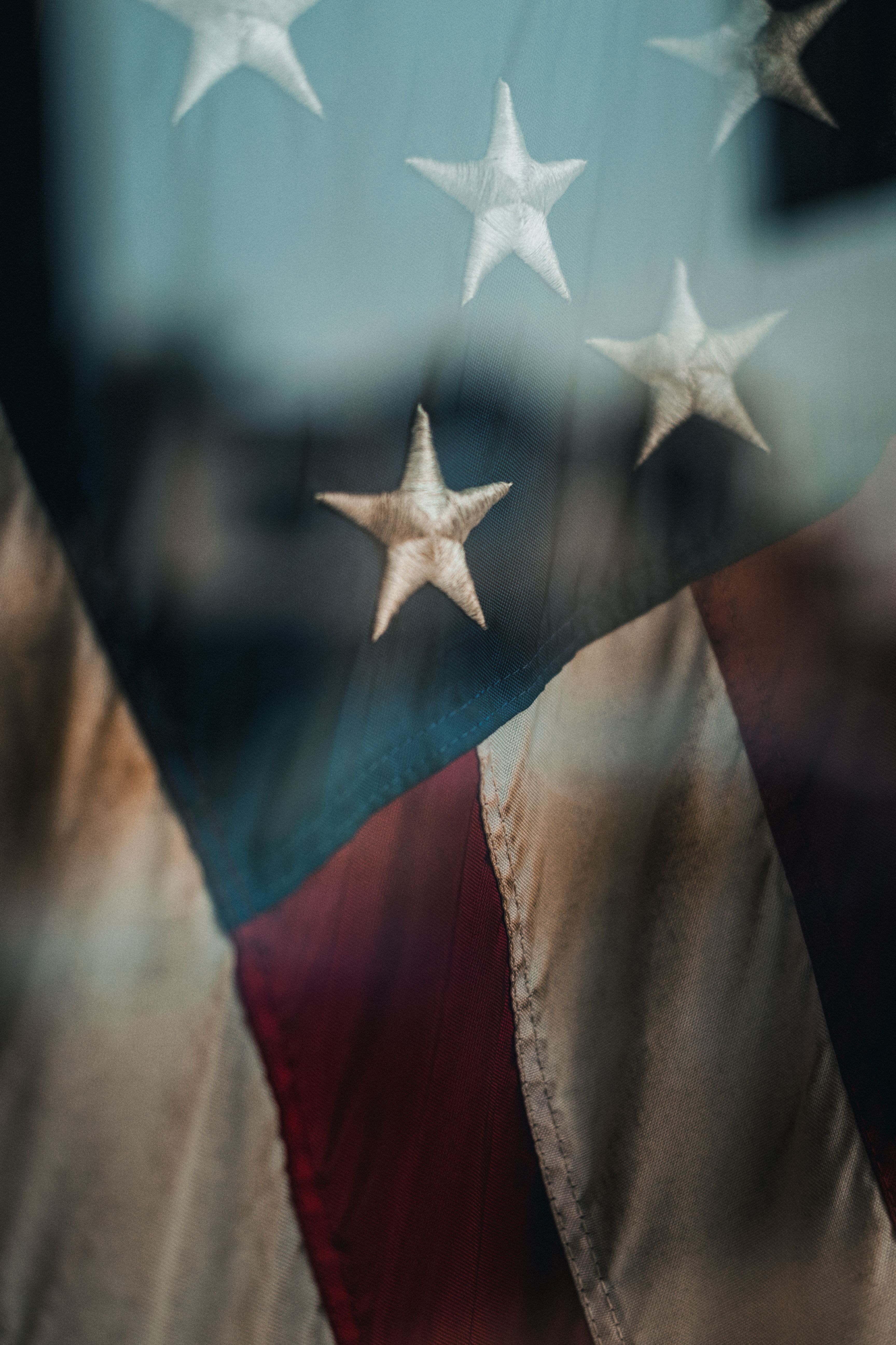 Artistic close-up of a vintage American flag displaying stars and stripes, evoking patriotism.