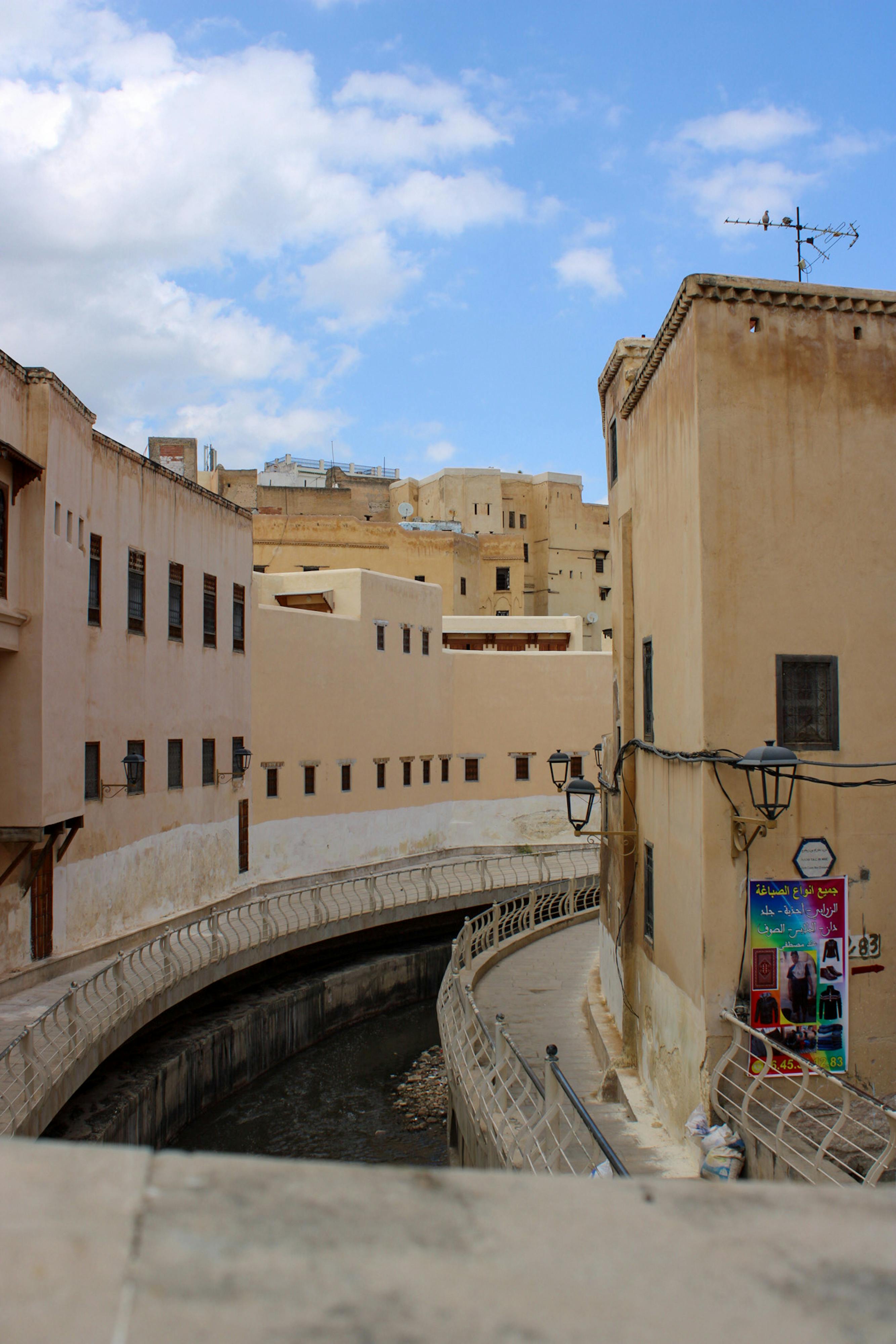 A scenic view showcasing traditional architecture alongside a canal under a bright blue sky.