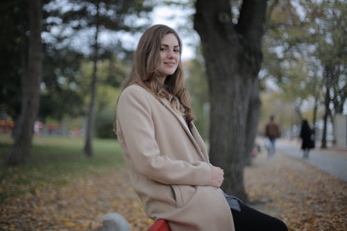 Happy millennial woman with red leaf enjoying autumn in park · Free ...