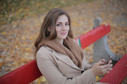 Woman in Gray Coat Sitting on Red Bench