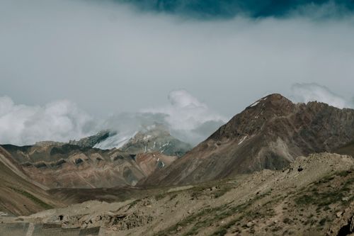 Free Scenic view of rugged mountains with clouds, ideal for travel and nature themes. Stock Photo