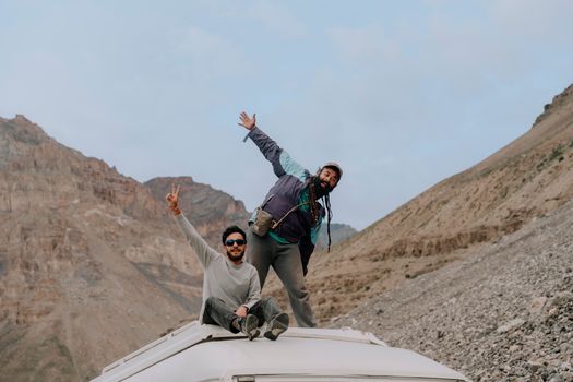 Two travelers enjoying a scenic mountain view during an adventurous road trip.