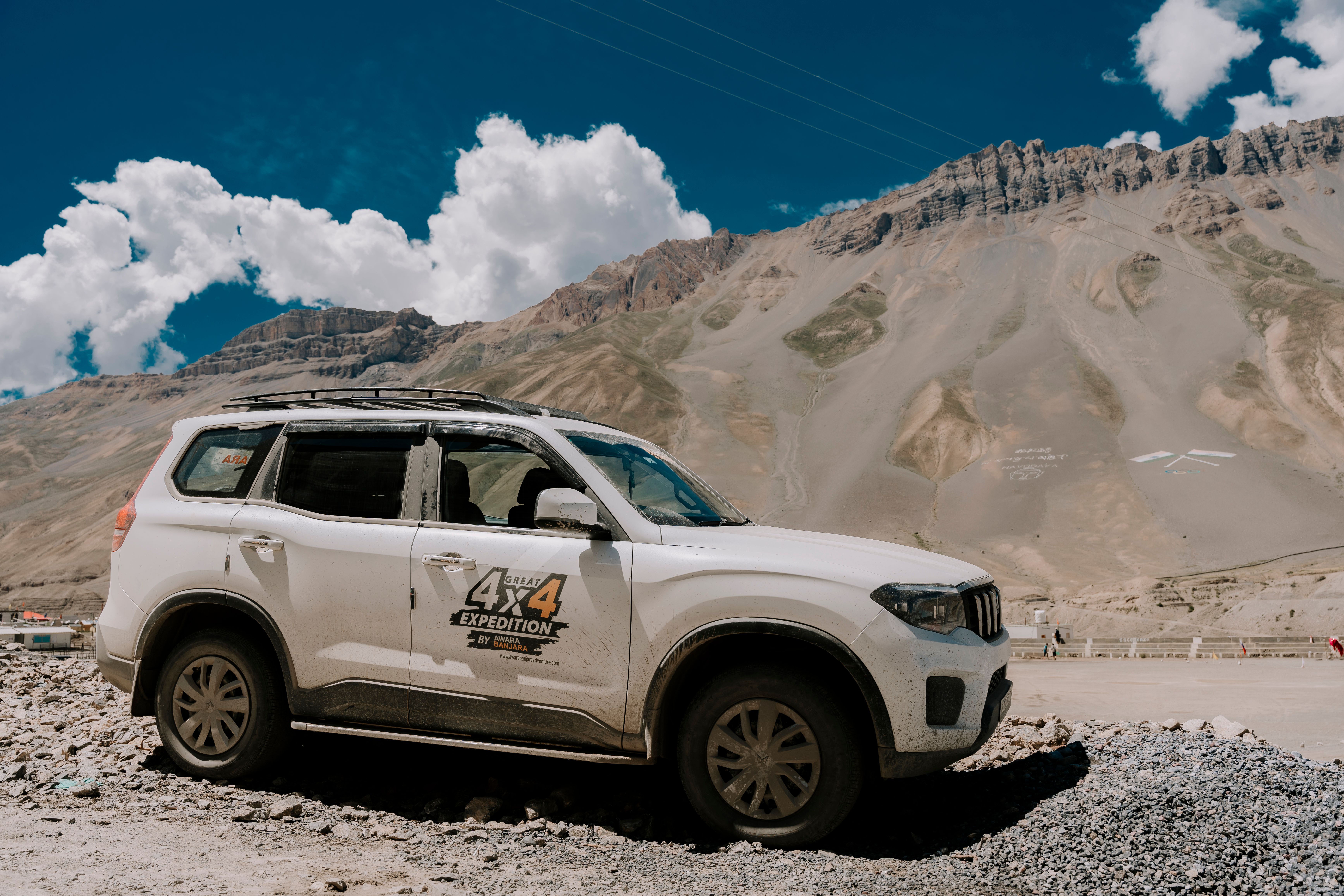 A 4x4 SUV exploring a rugged mountainous landscape on a clear day.