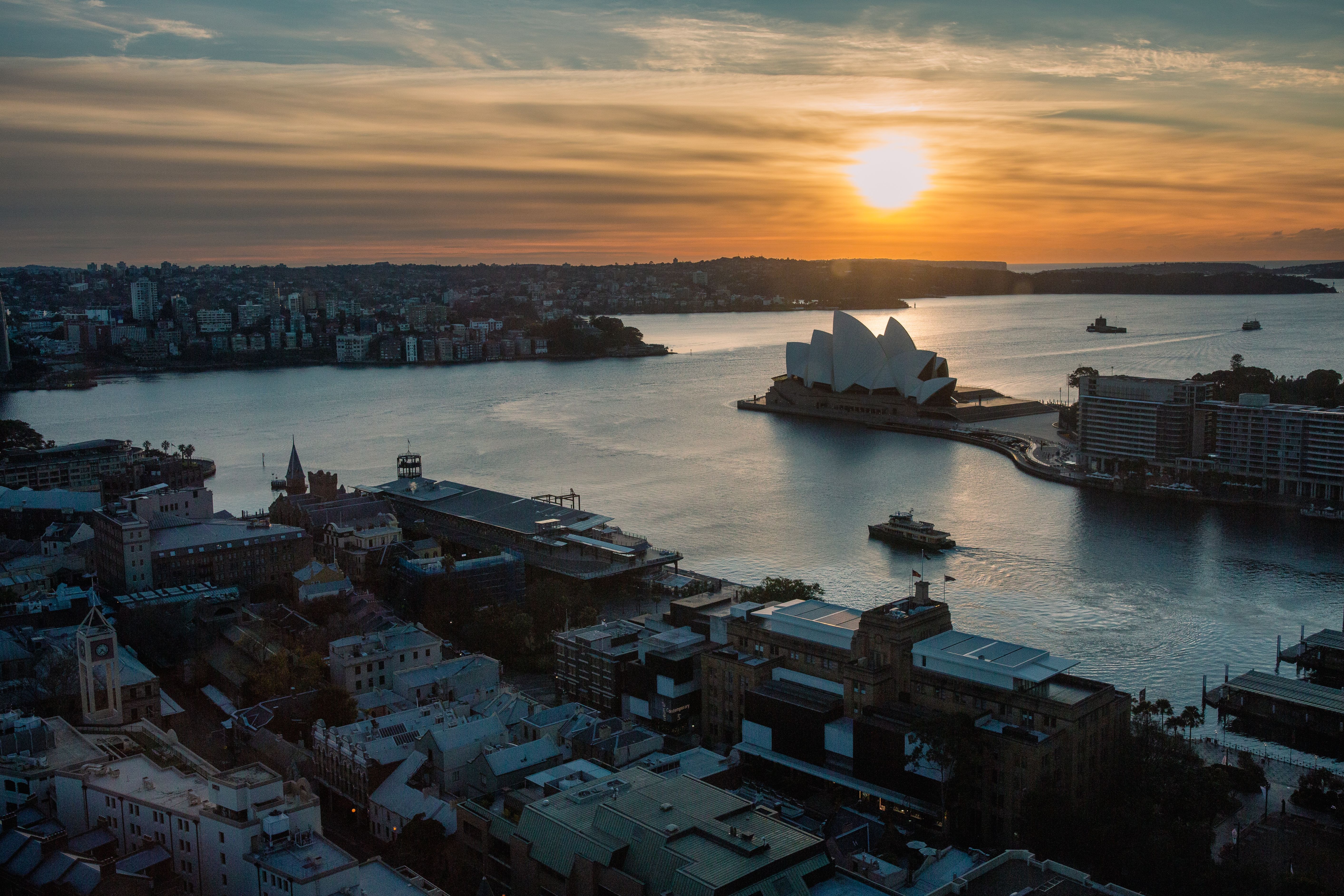 Aerial view of Sydney Opera House with sunset over the harbor skyline, New South Wales, Australia.