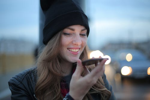 Woman in Black Knit Cap Holding Smartphone