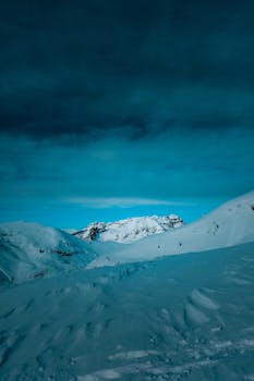 蓝天映衬下，白雪覆盖的山脉景色壮丽，非常适合冬季主题项目