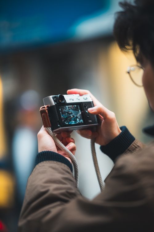 Free A photographer taking a street photo with a vintage camera, showcasing urban photography. Stock Photo