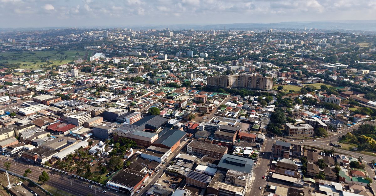 Stunning aerial view of Durban showing urban landscape, buildings, and greenery under a blue sky.