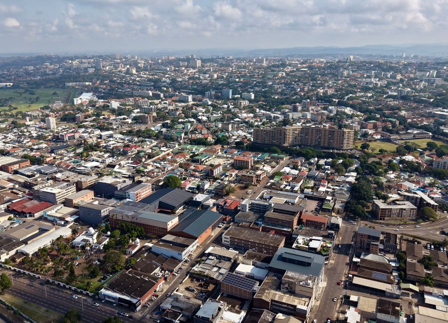 Stunning aerial view of Durban showing urban landscape, buildings, and greenery under a blue sky.
