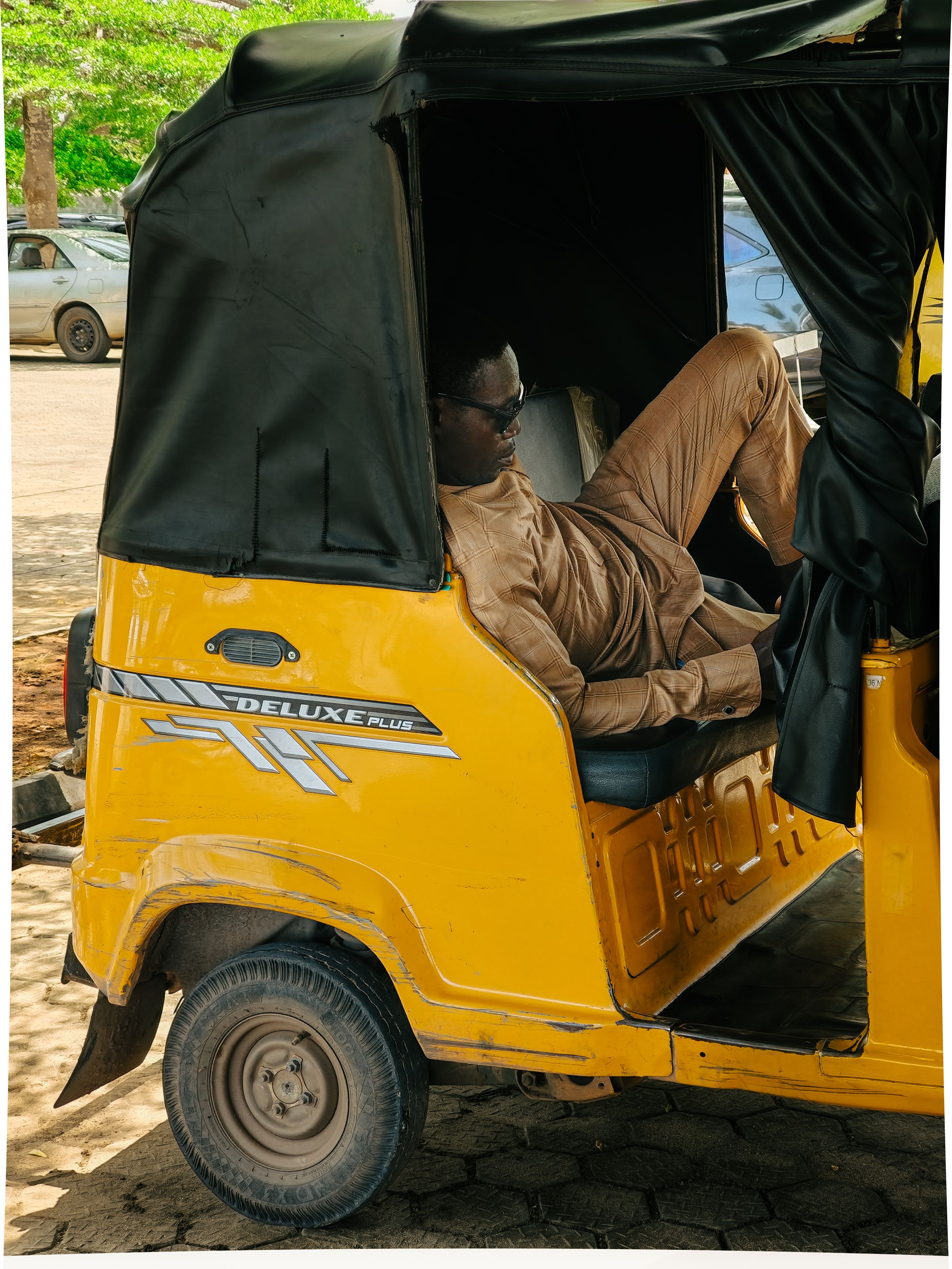 Man Relaxing in Yellow Auto Rickshaw on a Sunny Day · Free Stock Photo