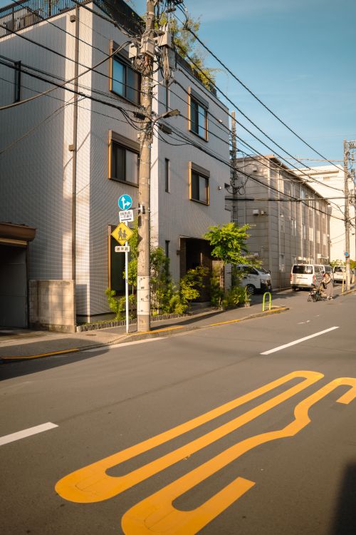 Free A sunny day on a calm Tokyo street with modern buildings and clear road markings. Stock Photo
