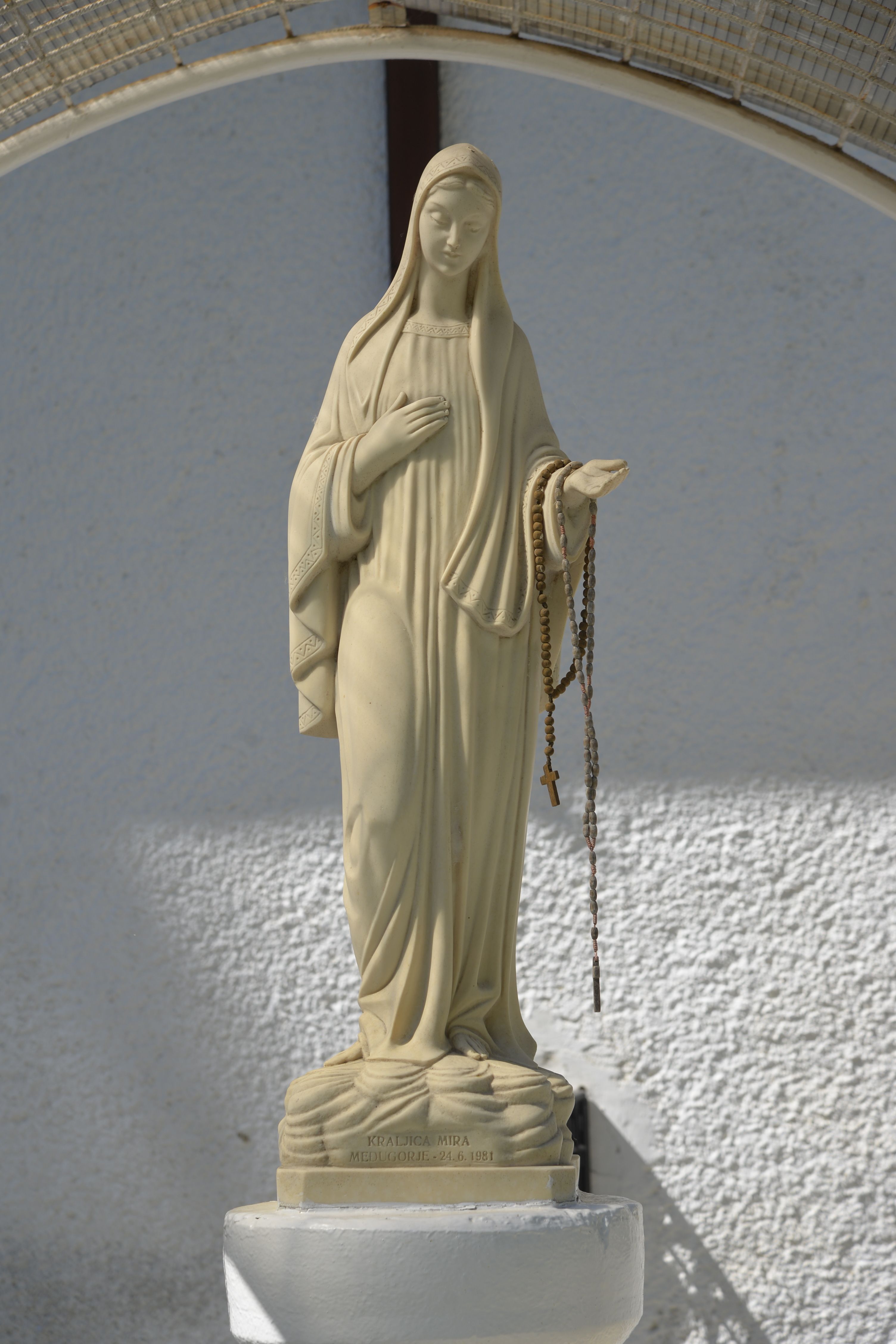 Close-up of a Virgin Mary statue holding a rosary in Bodrogszög, Slovakia.