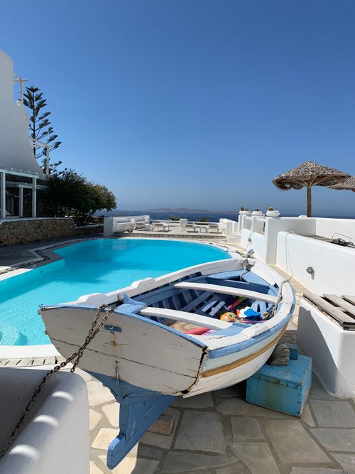 Free Charming Greek villa with a pool and traditional boat overlooking the tranquil Aegean Sea. Stock Photo
