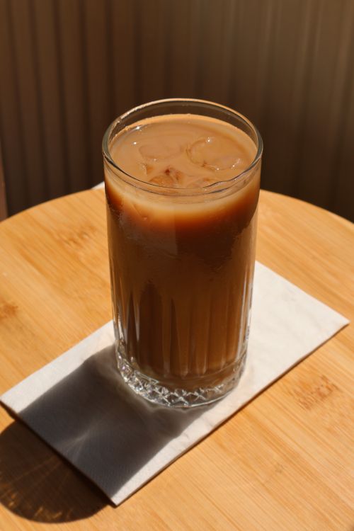 Free A glass of iced coffee sits on a napkin under natural light, exuding freshness. Stock Photo