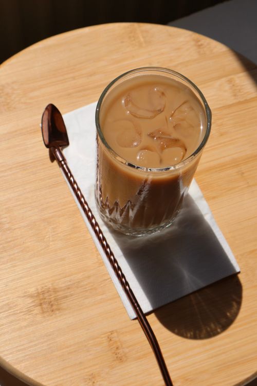 Free Top view of a chilled iced coffee on a wooden table with a metal straw. Stock Photo